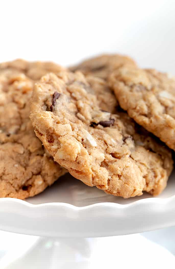 Cowboy cookies arranged overlapping on white cake plate