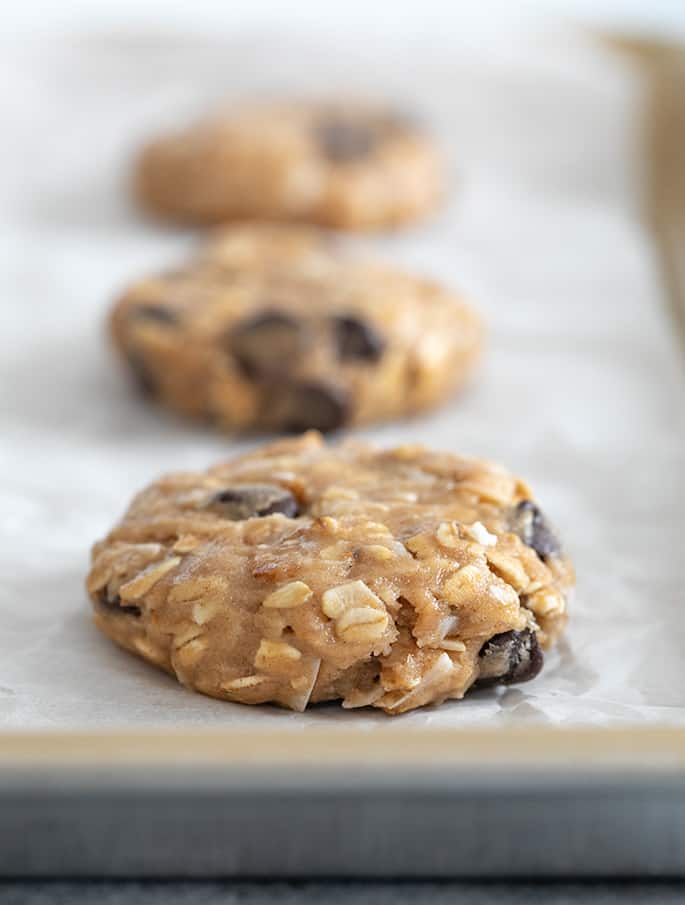 Raw cowboy cookies on white paper on tray