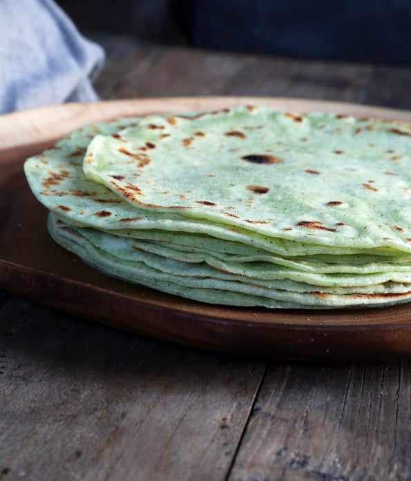 Side view of stack of zucchini flour tortillas on brown plate