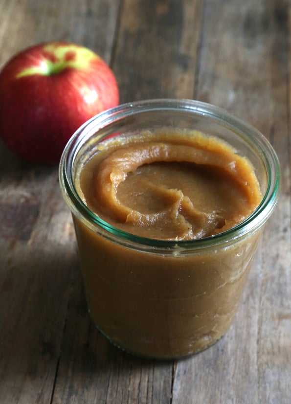 Apple butter in a jar on wooden surface 