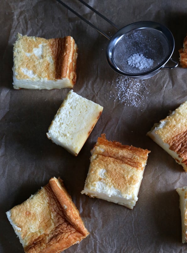 Overhead view of slices of custard cake on brown surface 