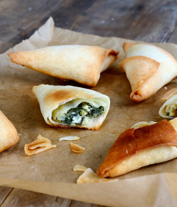 A close up of spanakopita on beige surface 