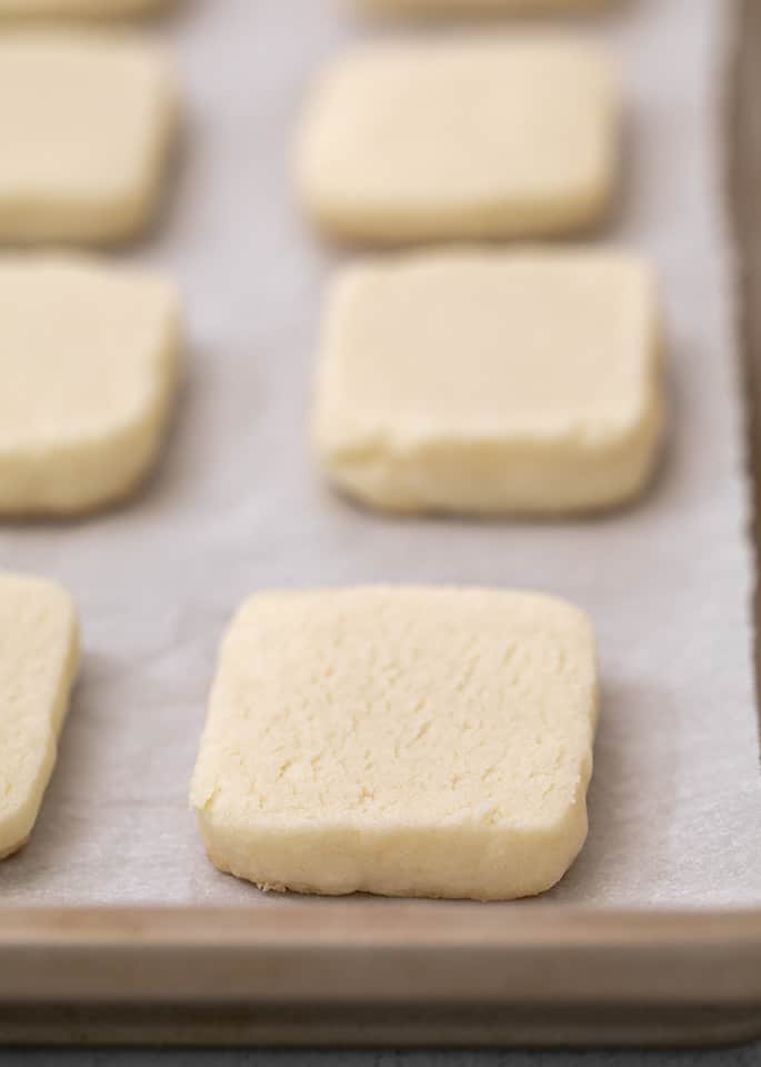 Baked plain shortbread cookies on white paper on tray