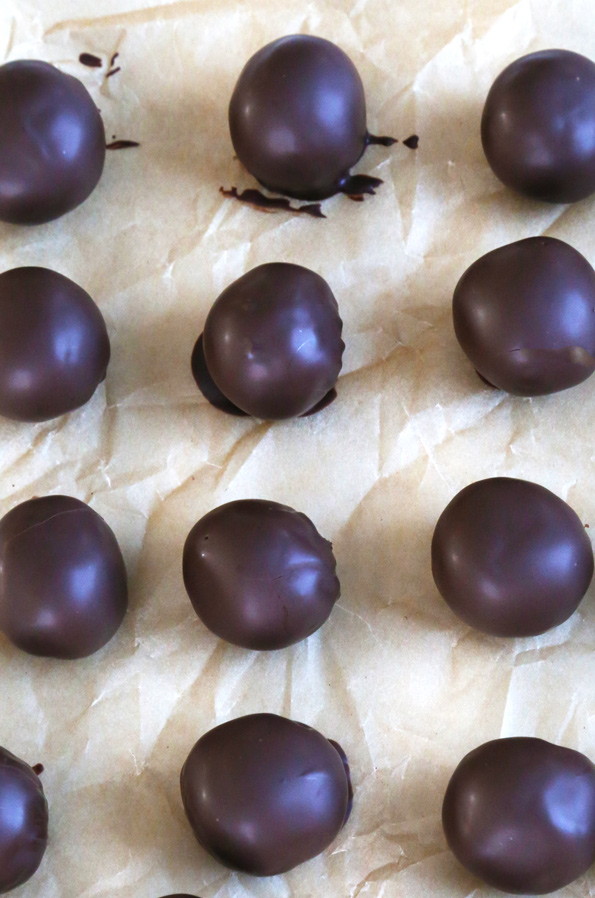 Overhead view of rum balls coated in chocolate on brown surface 