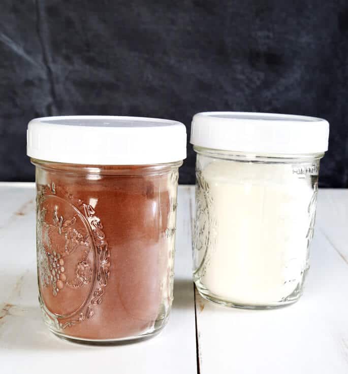 Pudding mix in 2 jars on white surface 