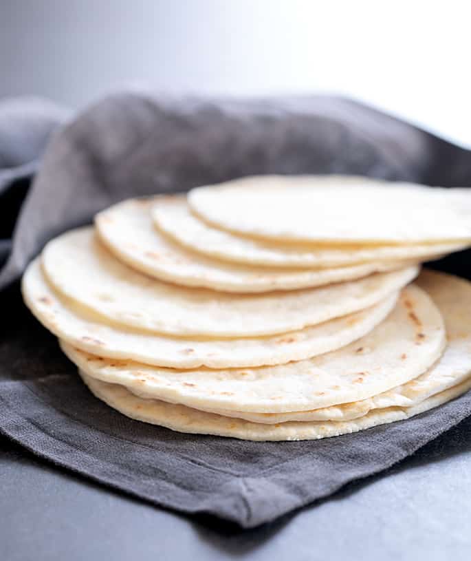 A stack of Paleo tortillas spread out in a cloth