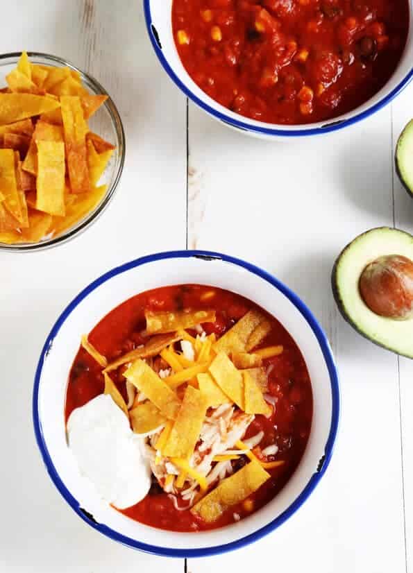 Overhead view of taco soup on white surface with avocados 