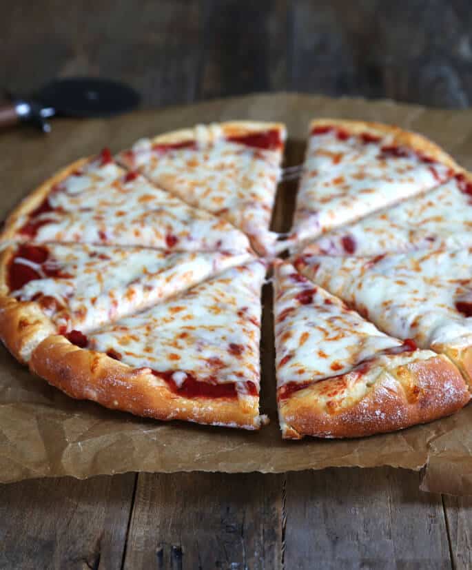 A pizza sitting on top of a wooden surface 