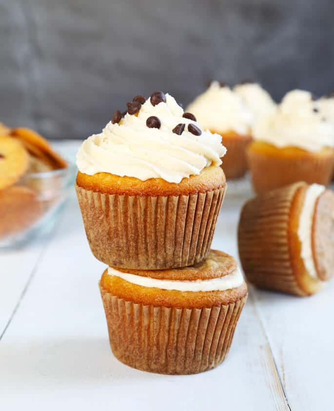 A stack of 2 cookie dough cupcakes on white surface 