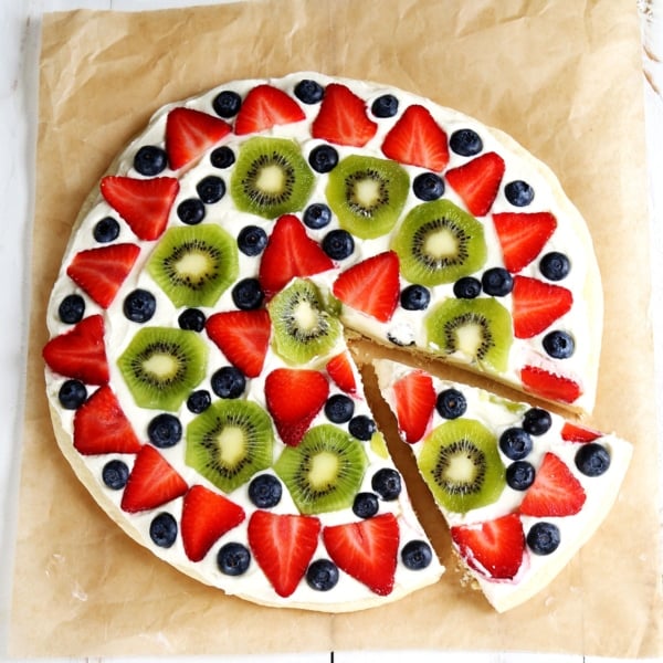 overhead image of gluten free fruit pizza with one slice cut