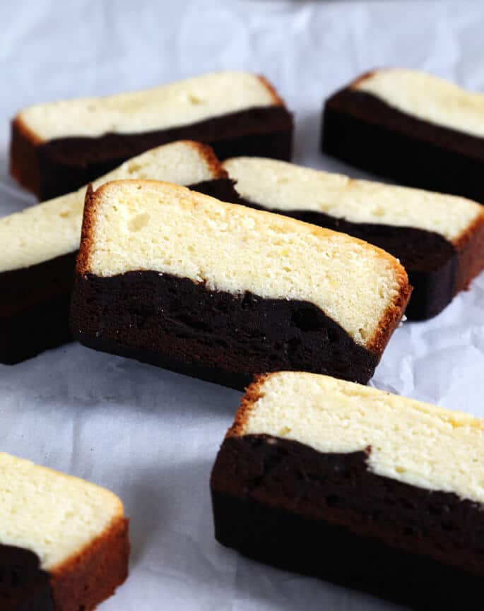 Slices of brownie butter cake on a white surface 