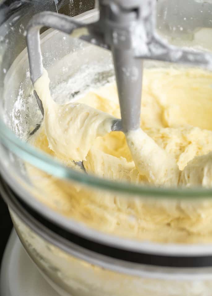 lemon cake batter in glass mixing bowl with paddle attachment