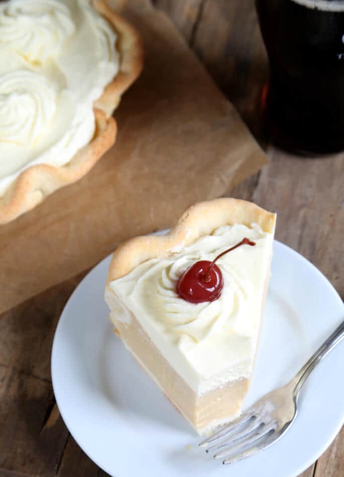 Overhead view of root beer float pie with cherry on top on white plate 