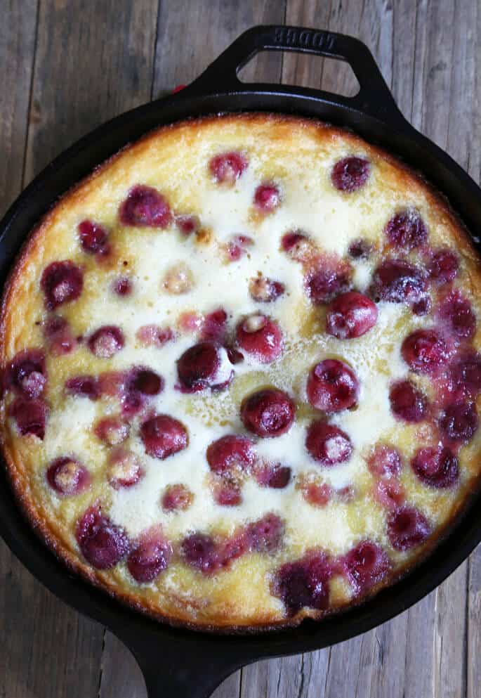 An overhead view of cherry clafoutis on wooden surface 