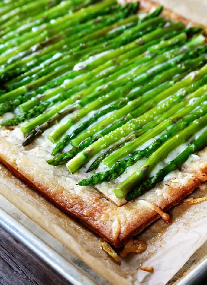 A close up of an asparagus tart on a metal tray