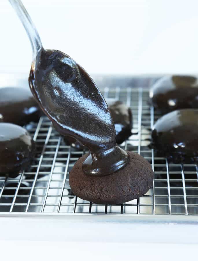 Chocolate sauce being placed on top of a Texas sheet cake cookie