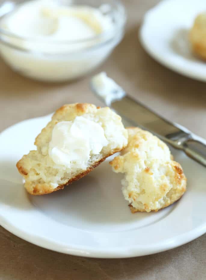 Plate with biscuits with butter and knife on plate. 