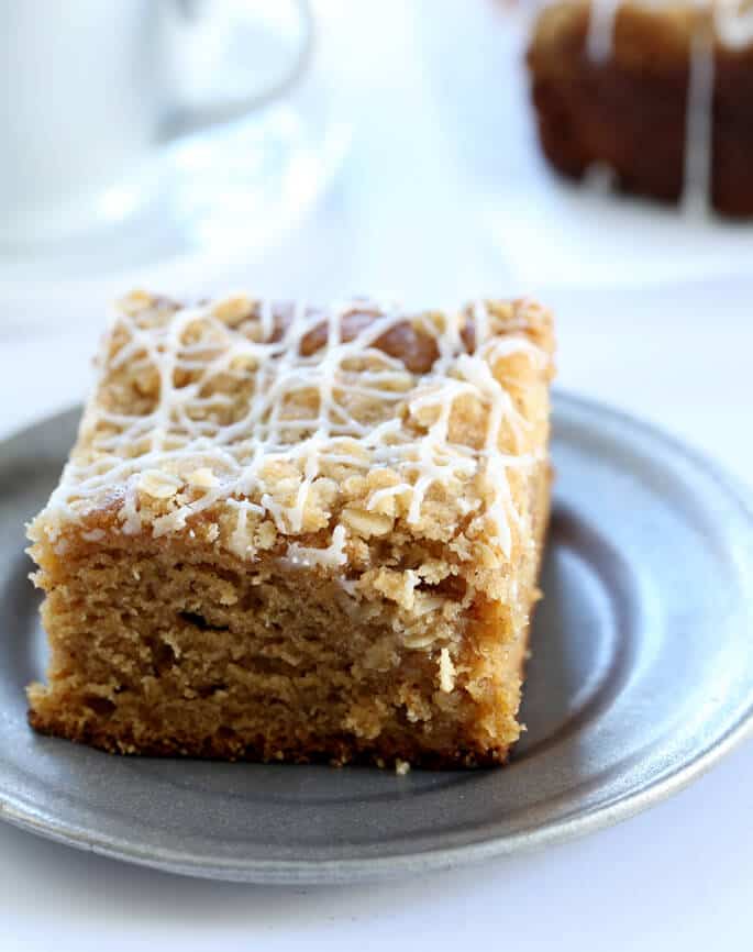 A close up of a slice of pumpkin coffee cake on a silver plate 