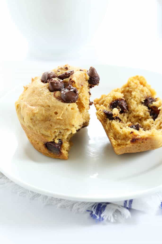 A close up of the inside of a pumpkin chocolate chip muffin on a white plate 