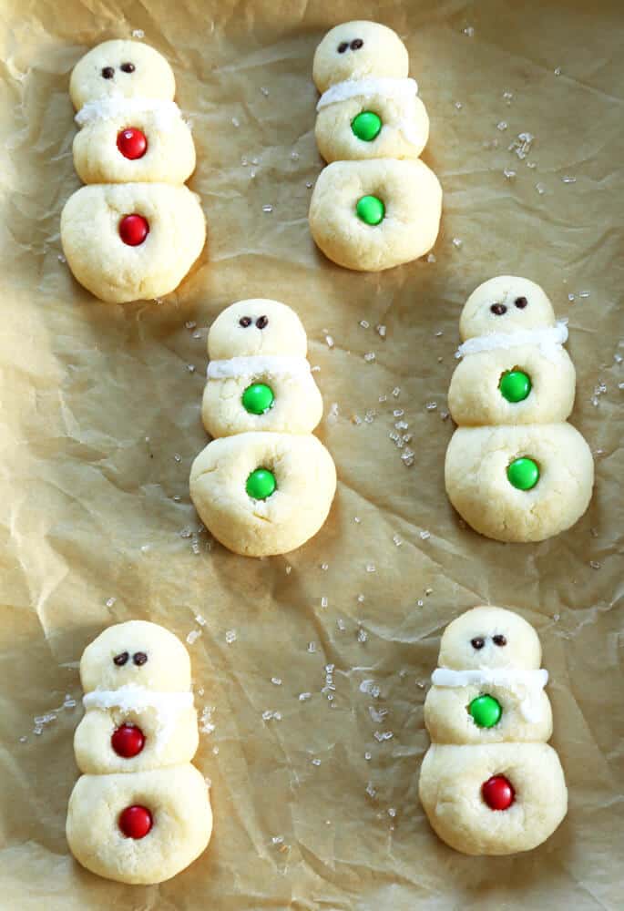 Overhead view of snowman sugar cookies on parchment paper