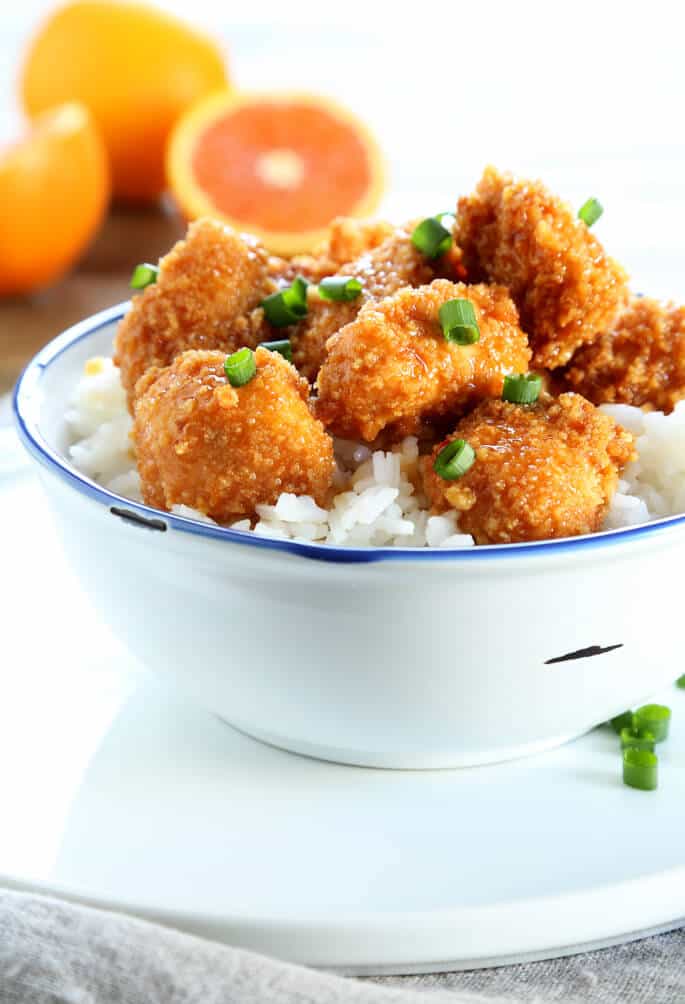 gluten free Chinese food recipe for orange chicken in white bowl on white plate