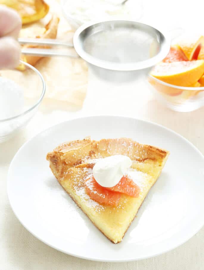 Large gluten free dutch baby pastry on a white plate 