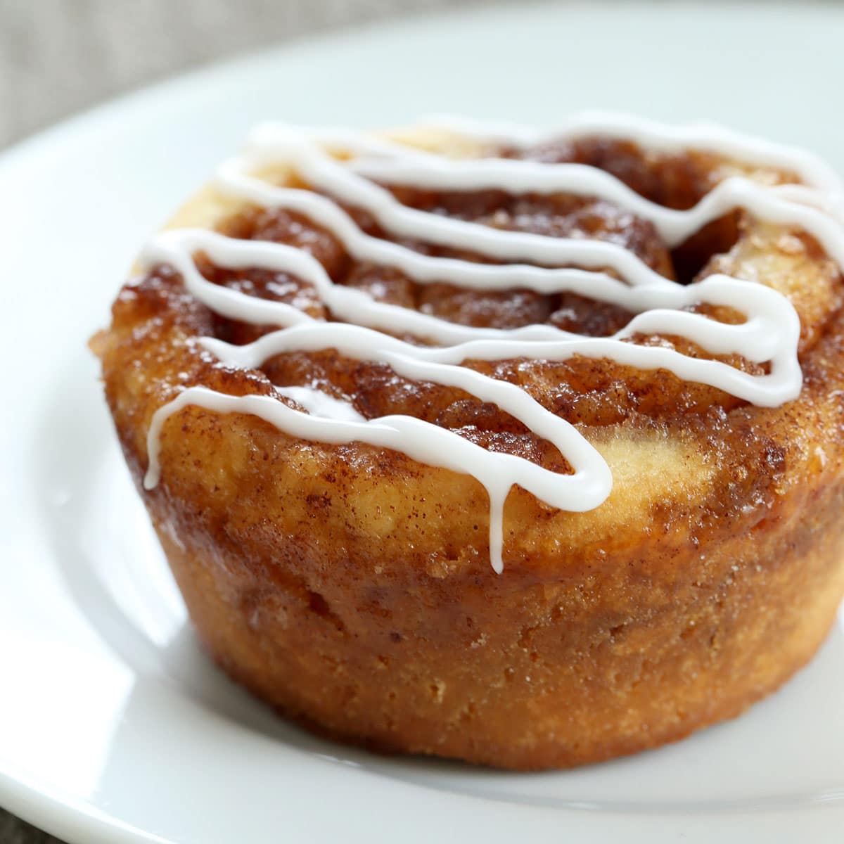 gluten free yeast free cinnamon rolls on small white plate with white glaze