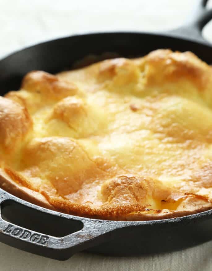 Close up of large pancake style pastry in a black pan