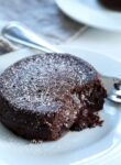 A close up of a chocolate lava cake on a white plate