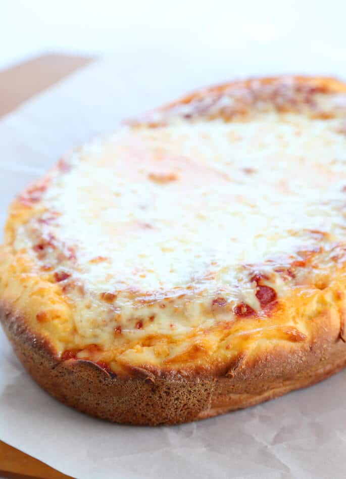 A close up of deep dish pizza on white surface