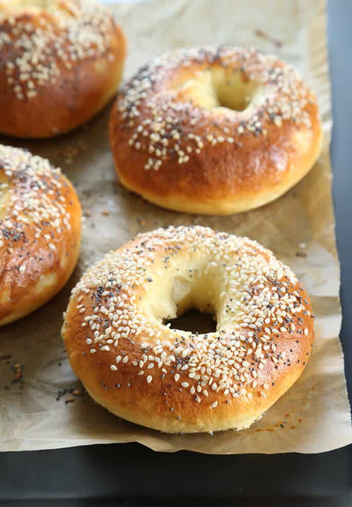 A close up fo bagel with seeds on biege paper