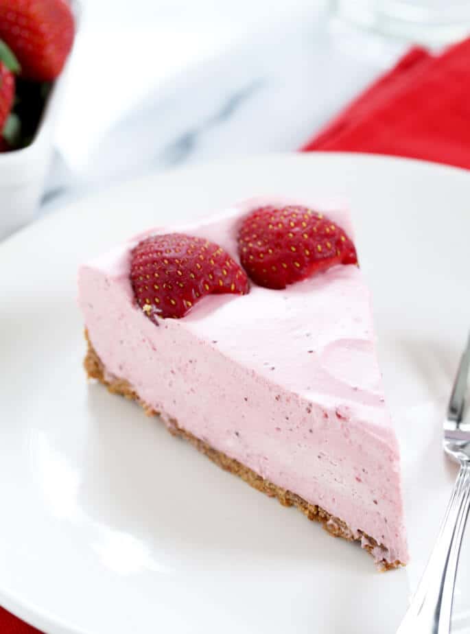 A piece of strawberry cheesecake on a plate.