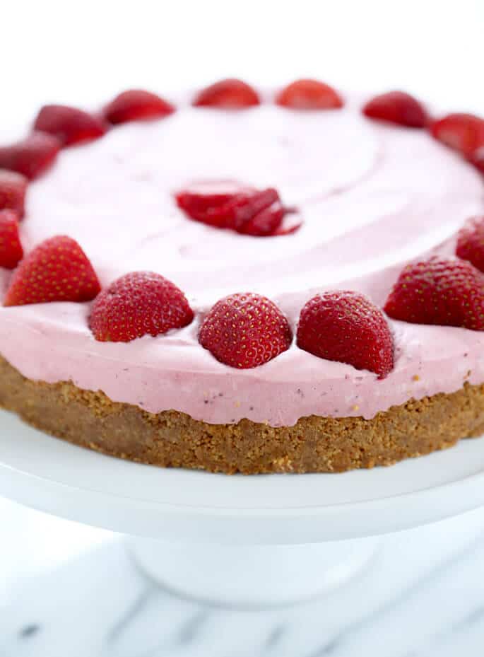 A closeup image of gluten free strawberry cheesecake with strawberries on top.