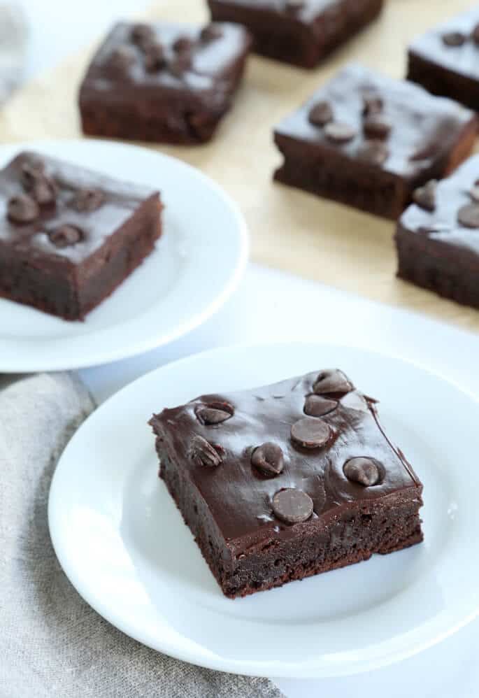 Flourless brownies displayed on individual small white plates.