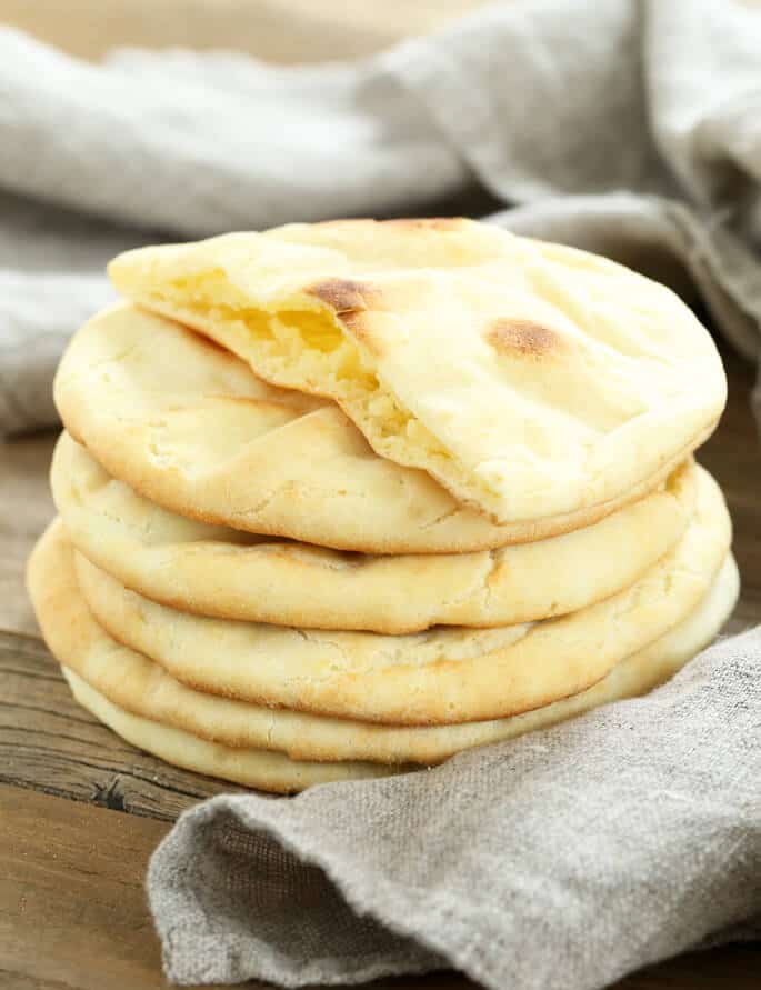 Stack of 6 pieces of pita bread on a wooden surface 