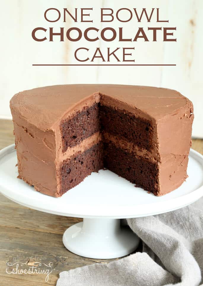 A gluten free chocolate cake on a cake plate with two slices removed and the words "one bowl chocolate cake"