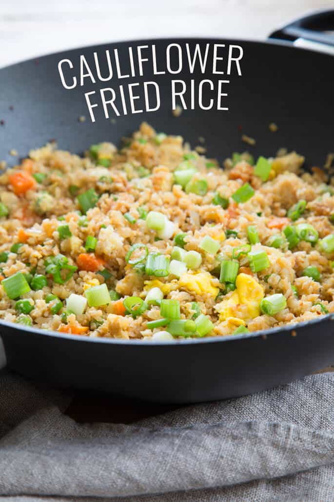 Side view of cauliflower fried rice in black pan