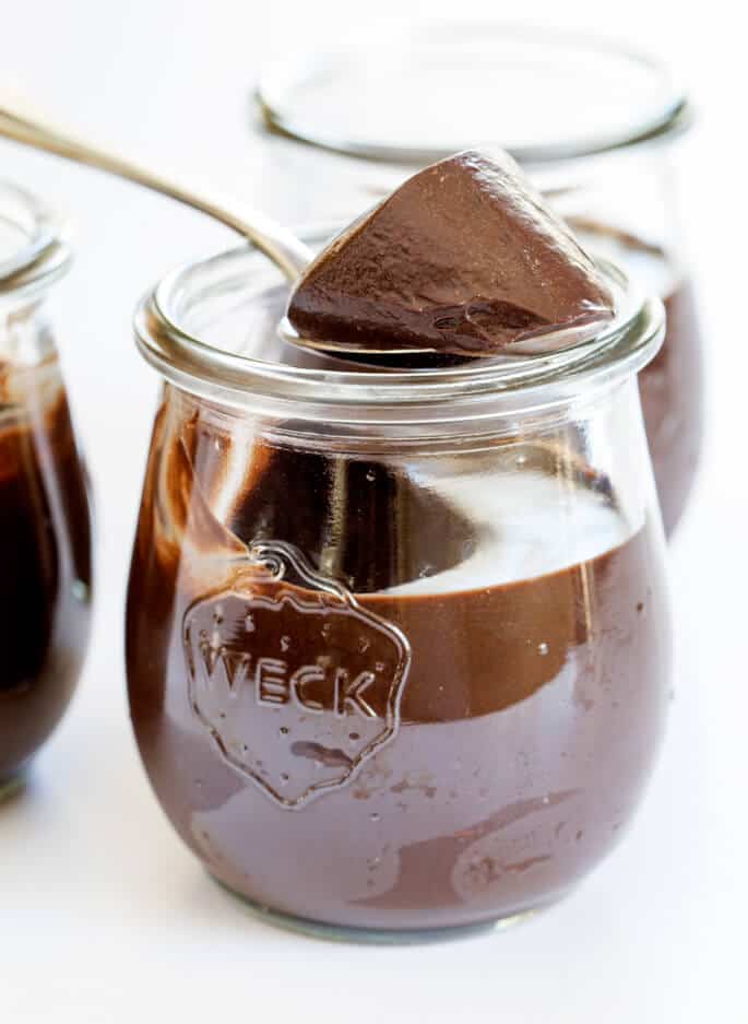 Close up of chocolate mousse in a jar being scooped out