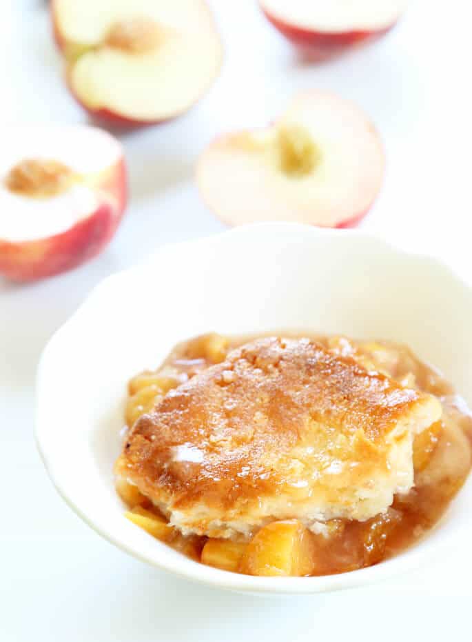 A close up of gluten free peach cobbler in a white dish