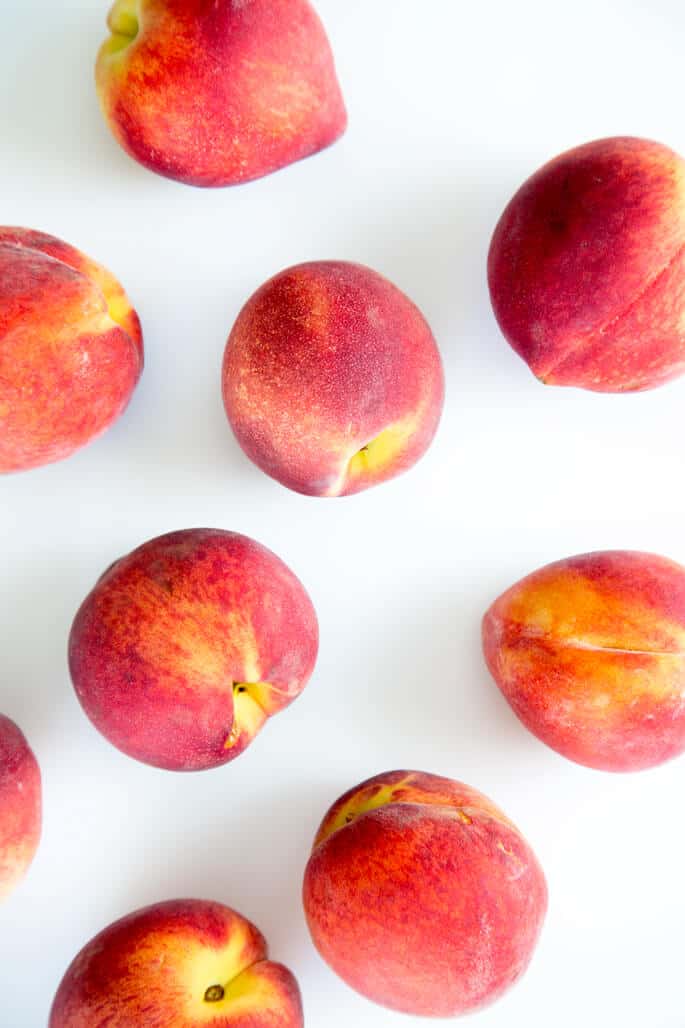 Overhead view of peaches on white surface