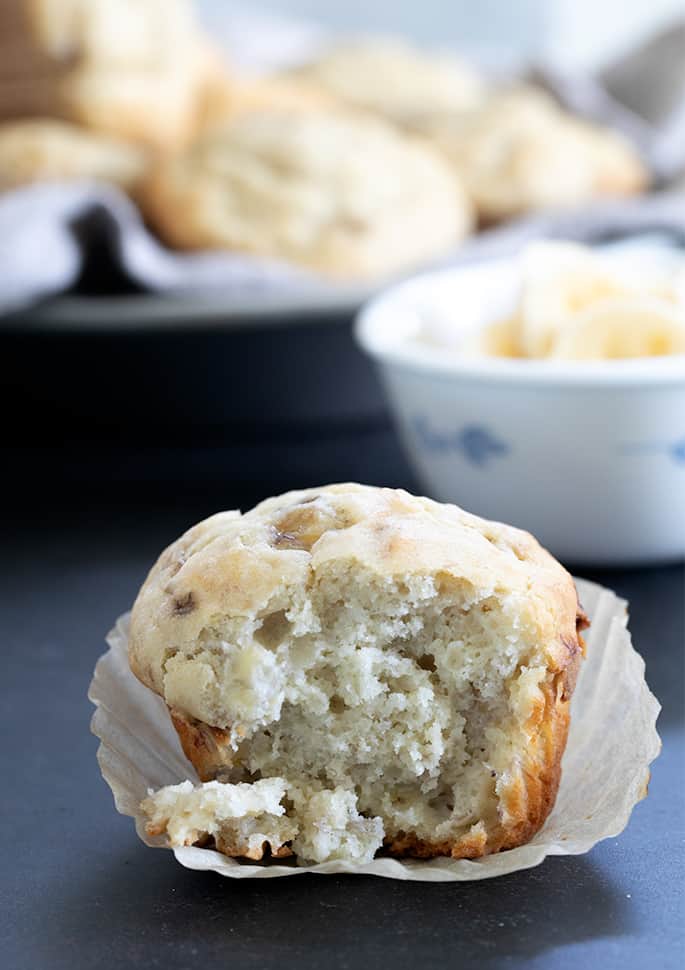 plate topped muffin sitting in peeled liner with front of muffin removed and moist crumbs attached