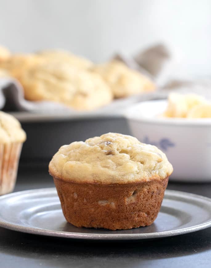 Single muffin very pale light brown on top and golden brown on sides on small metal plate