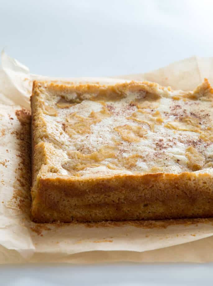 Side view of apple custard cake on brown parchment paper