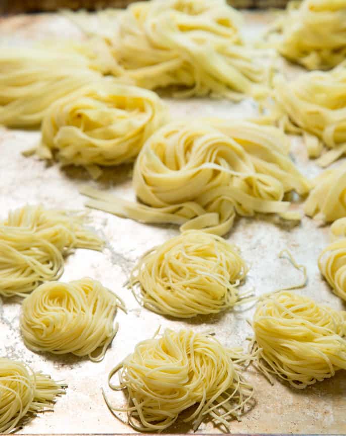 A close up of thinner piles of pasta on metal surface