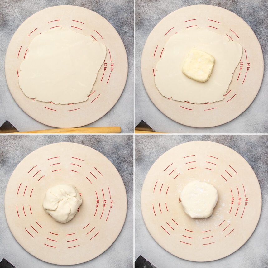 Light tan round pastry board with rolled out gluten free puff pastry dough with flat yellow butter square on top, and then dough wrapped around butter