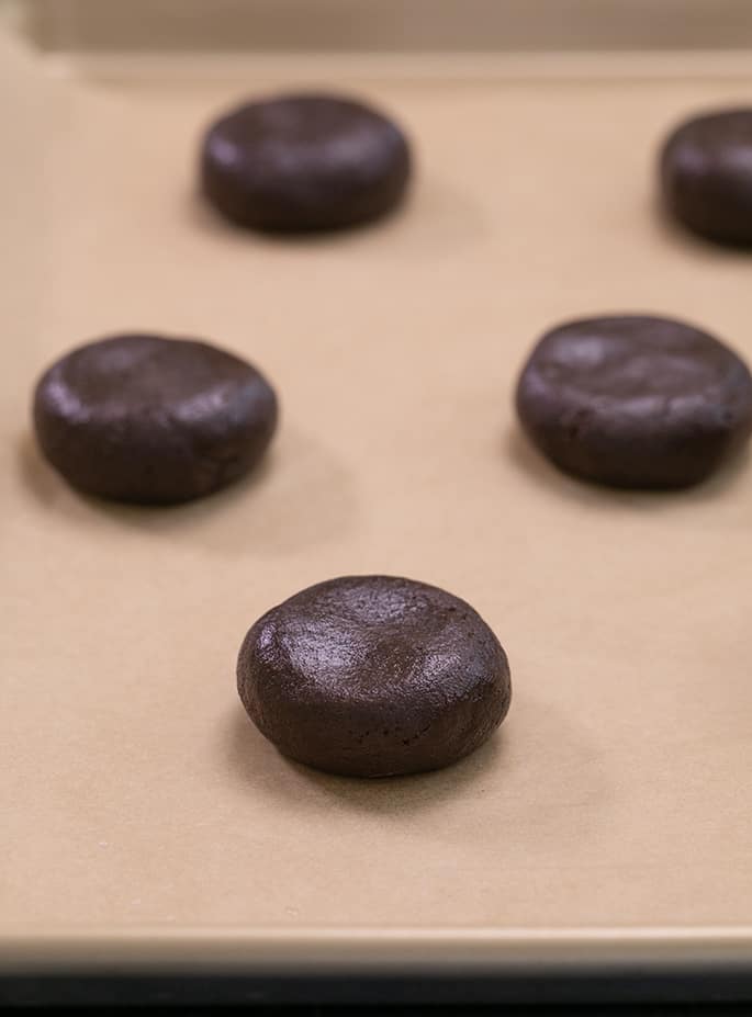 Shaped chocolate crinkle cookie dough on brown paper