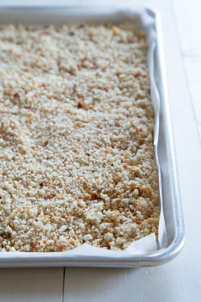 Close up of toasted gluten free bread crumbs on metal tin lined with white paper