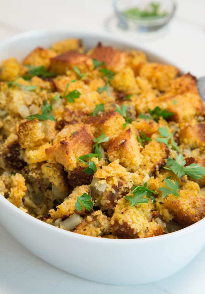 A close up of cornbread stuffing with herbs on top