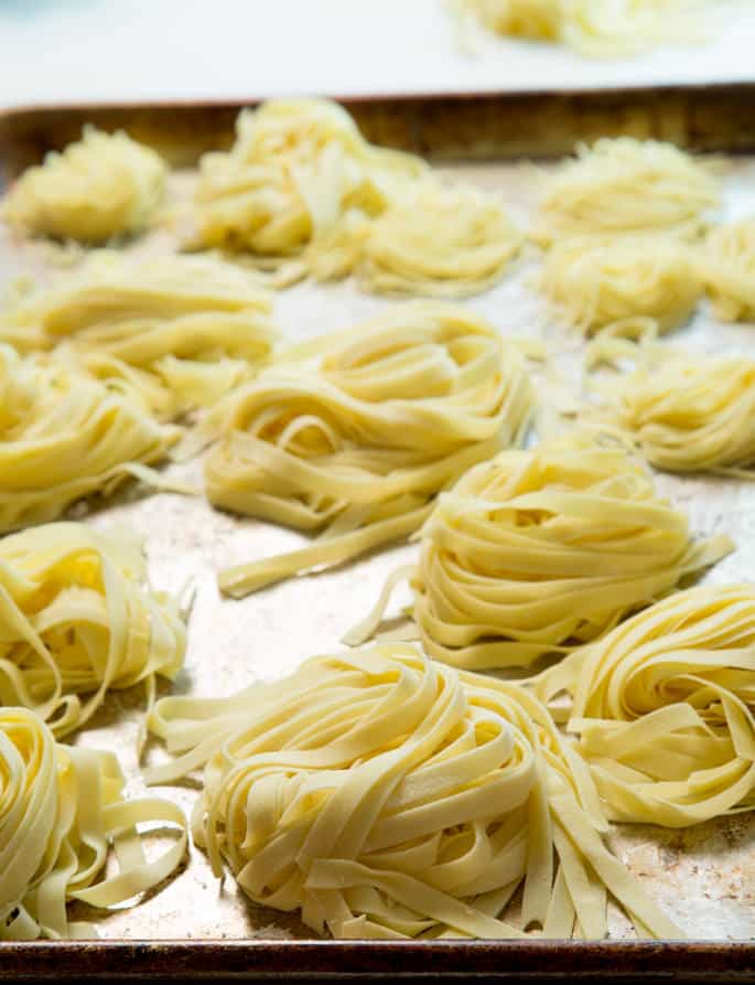 A close up of thicker piles of pasta on metal surface