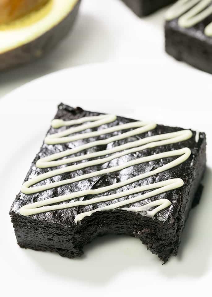 A plate with avocado brownie with white zigzag pattern on top